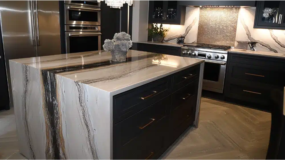 Luxurious Kitchen With Dramatic Waterfall-Edge Island, Dark Cabinetry, Bold Marble Veining, And Stainless Steel Appliances.